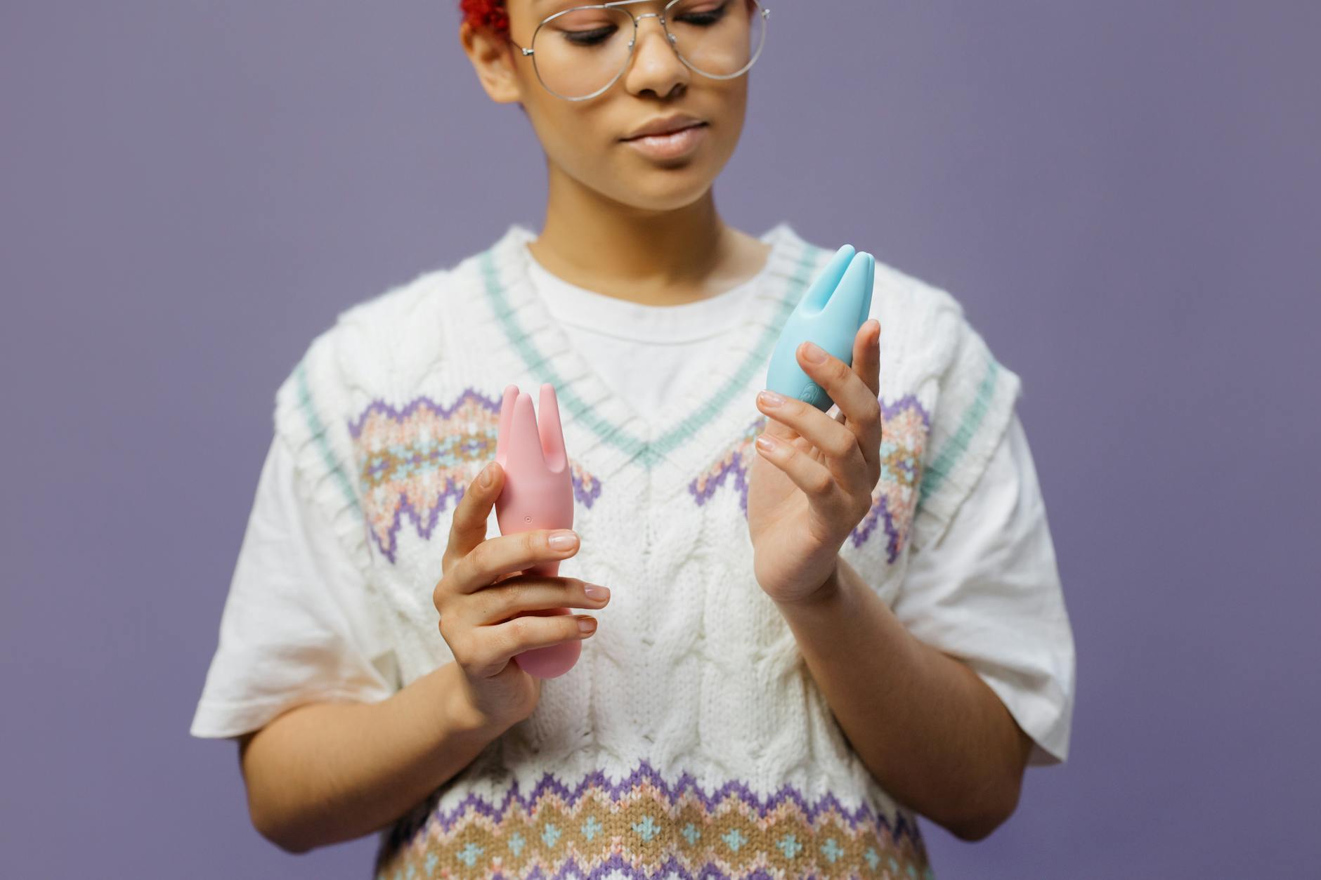 Hands holding colorful silicone lemon vibrators in contemplative pose