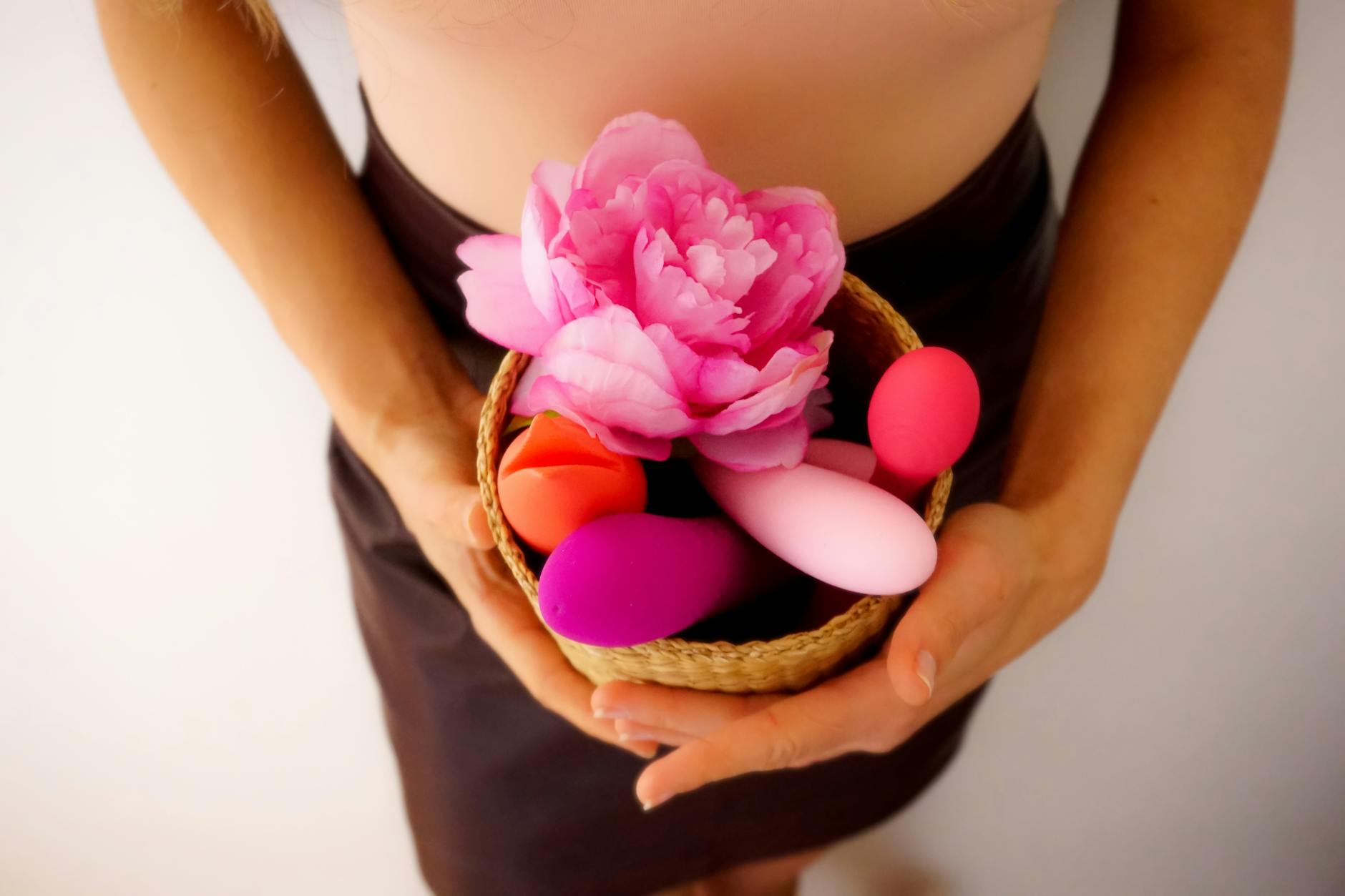 Woman with glasses holding colorful vibrators with intention and calm