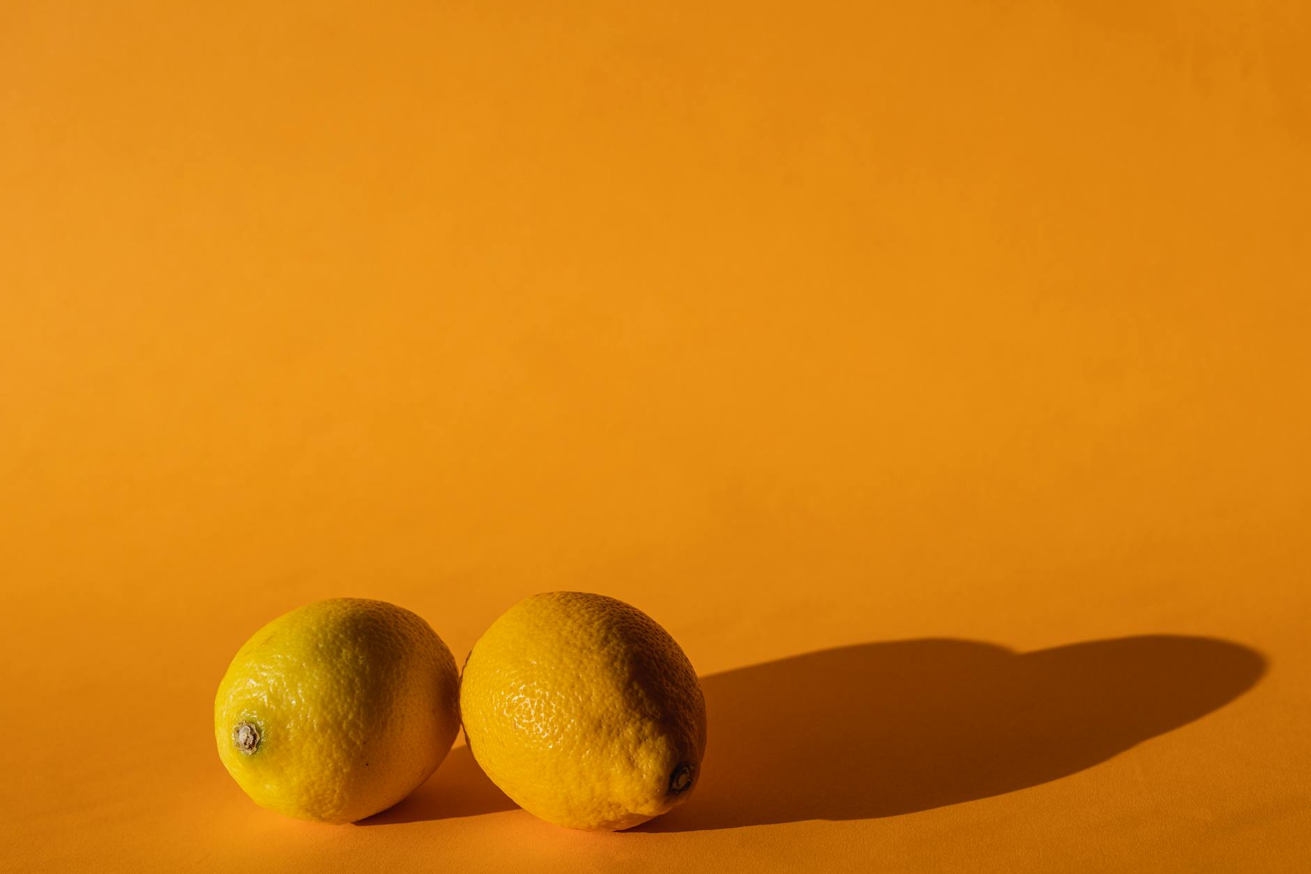 Colorful lemon clitoral vibrators arranged on a bright yellow surface showcasing various shapes and designs